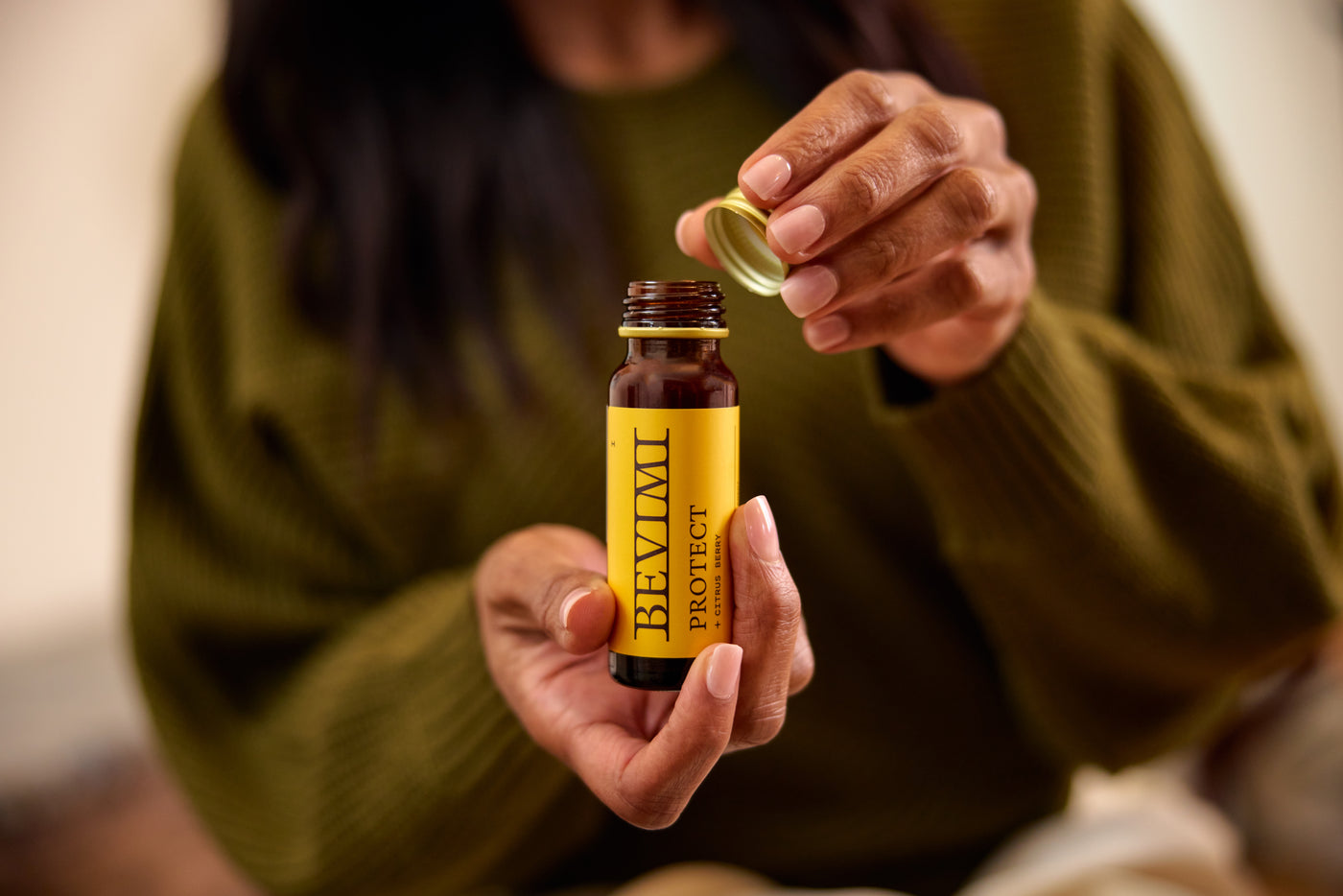 A person holding an open Bevimi Uno Protect bottle