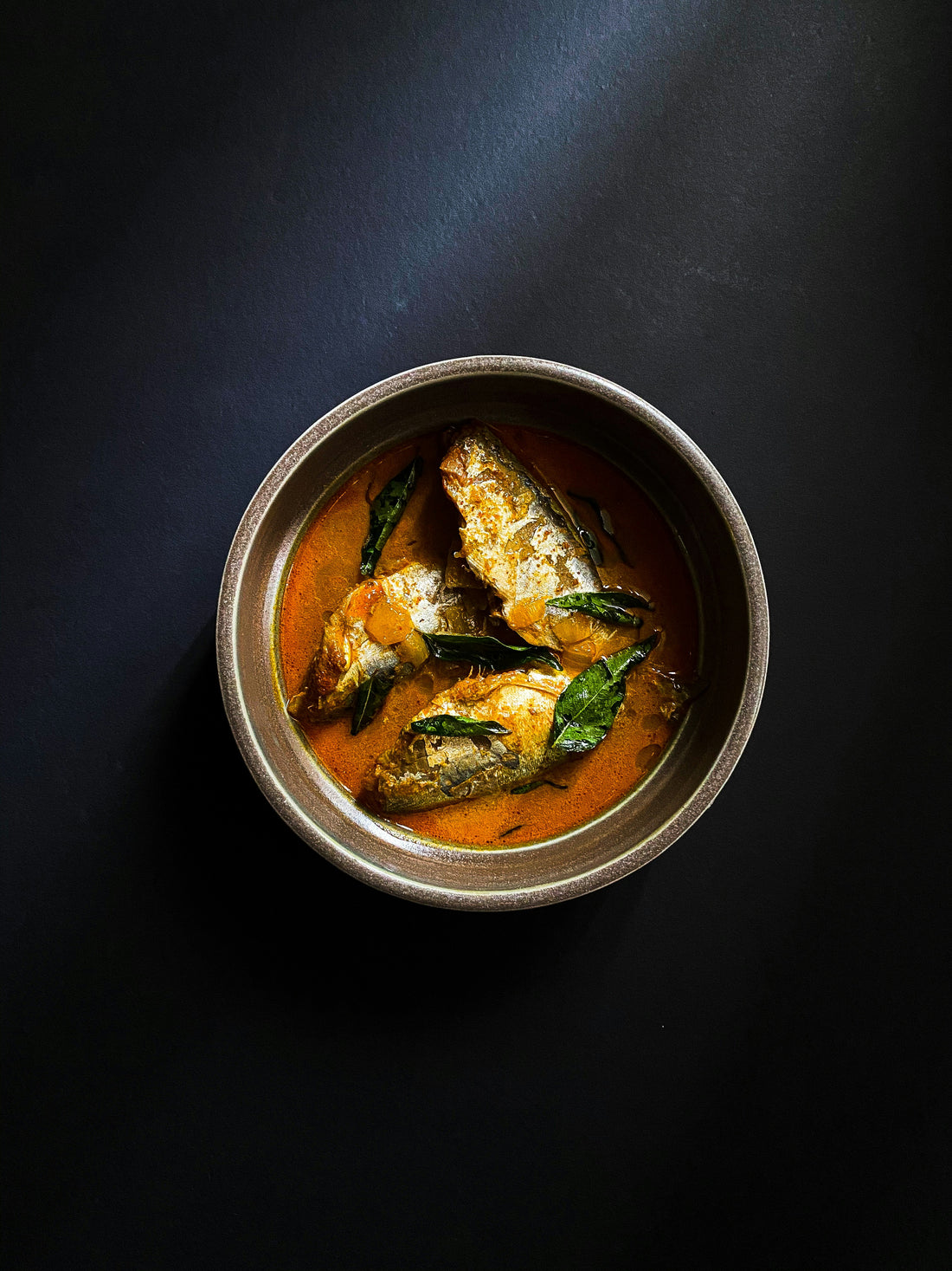 A bowl of fish in a rich sauce
